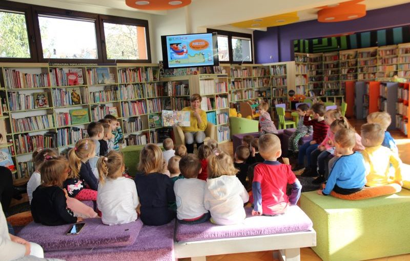 dzieci siedzą na kanapie. kobieta siedzi
