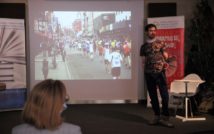 młody mężczyzna w t-shircie na tle zdjęcia z maratonu