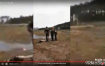 screen przedstawia zdjęcie z poligonu.widać 3 osoby stojące tyłem.w tle las