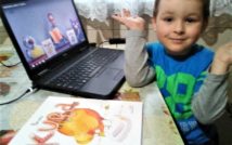 zdjęcie przedstawia po lewej stronie otwarty laptop z odtwarzanymi warsztatami.po prawej stronie uśmiechnięty chłopiec.na dole zdjęcia leży książka na stole pt. Kura, co tyła na diecie
