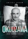 okładka książki, centralnie postać mężczyzny w kraciastej koszuli, za którym stojąca z tyłu, na tle regału z książkami kobieta, trzyma rozpoztartą białą tkaninę. U góry białe litery: Dmitrij Bykow , u dołu duży napis: Okudżawa i mniejsze litery: życie, piosenki, legenda